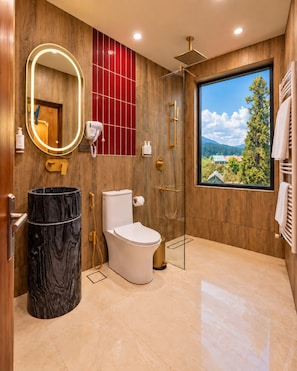 A modern bathroom with a toilet, bidet, and a glass-enclosed shower. - House of Khazir (Gulmarg)