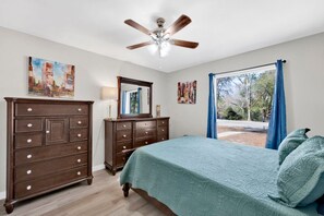 A bedroom with a bed, dresser, ceiling fan, and artwork on the walls. - Flint Ridge (Mobile)