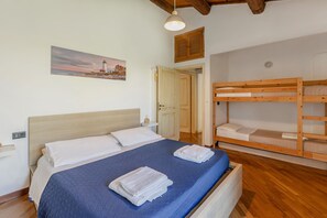 A bedroom with a single bed, a bunk bed, a painting, and a door. - Villa Stefano by Anita Villas (Campofilone)