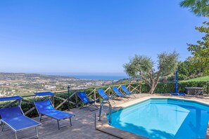 A pool area with blue lounge chairs and a view of the landscape. - Villa Stefano by Anita Villas (Campofilone)