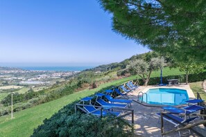 A pool area with lounge chairs and a view of the landscape. - Villa Stefano by Anita Villas (Campofilone)