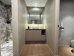 Ein modernes Badezimmer mit Waschtisch, Spiegel und Toilette.