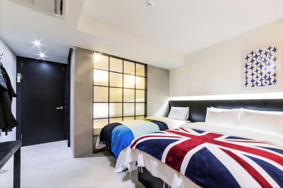 Ein Hotelzimmer mit einem Bett, einem Kleiderschrank, einer Sitzecke mit einem Tisch und einer Wandleuchte.