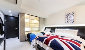 Ein Hotelzimmer mit einem Bett, einem Kleiderschrank, einer Sitzecke mit einem Tisch und einer Wandleuchte.
