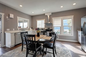 A modern kitchen with a dining area, featuring a central island, built-in appliances, and large windows. - 4B2B DT Everett Ideal for Medical/Corporate/Insurance Placement close Hospital (Everett)