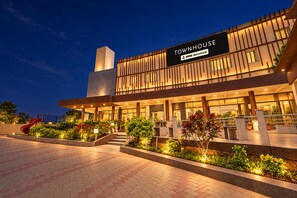 Un hotel moderno con un letrero llamativo que dice 'TOWNHOUSE' y 'ovo-Serviced'.