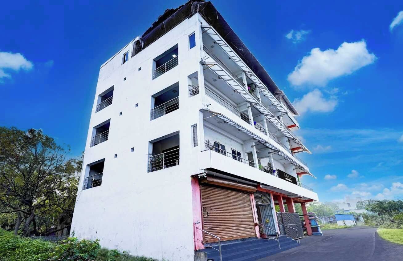 A multi-story building with a flat roof, large windows, and a closed garage door.