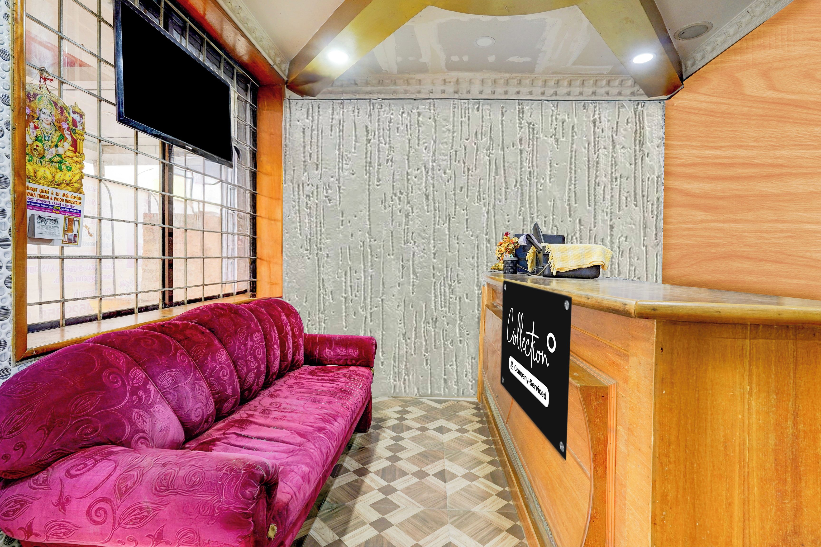 Zona de recepción con un sofá, un mostrador y una pared con estampado de papel.
