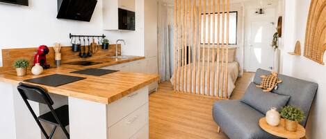 A modern apartment with a kitchen, dining area, and living room.