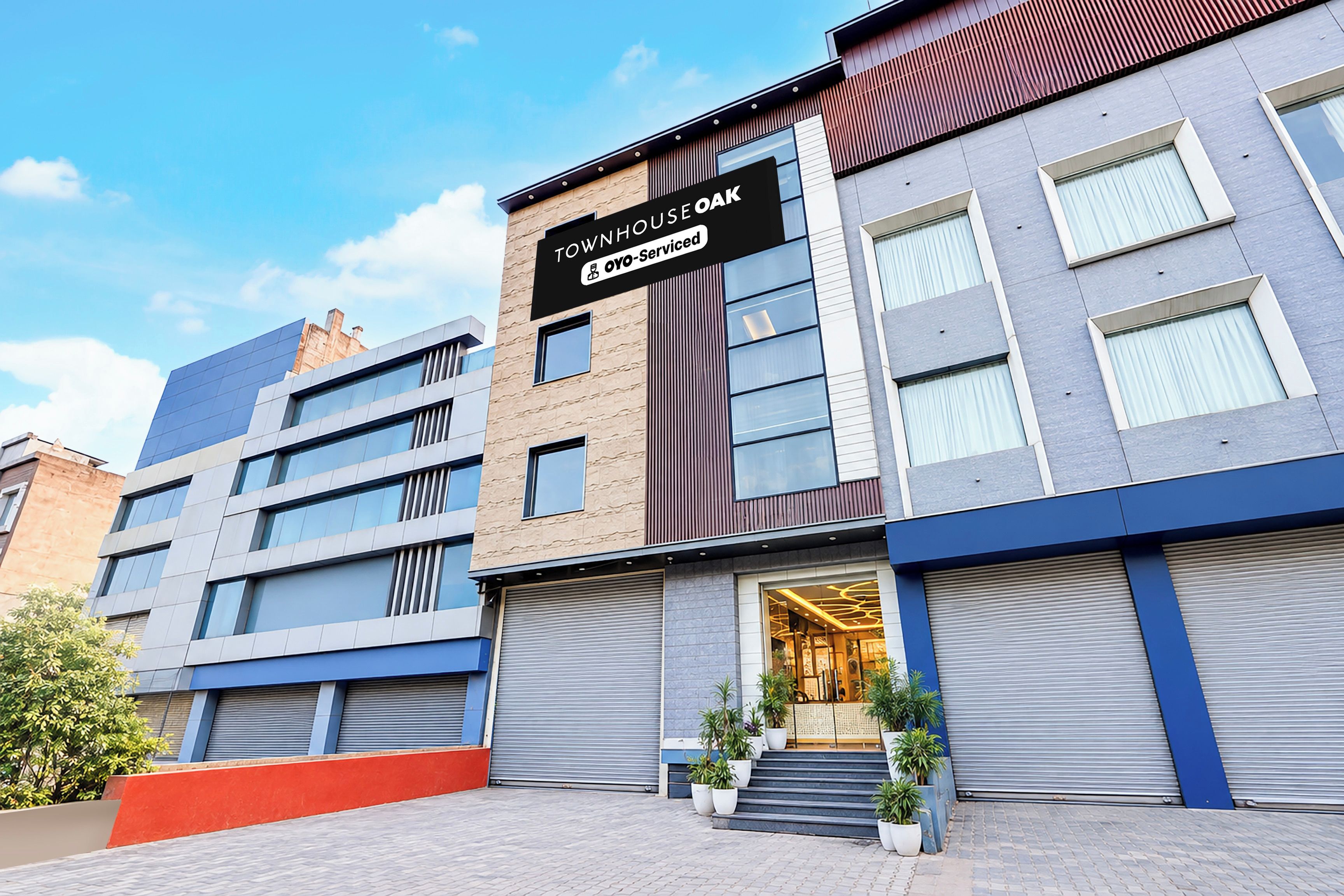 A modern building with a sign reading 'TOWNHOUSE OYO-Serviced.'