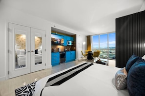 A modern hotel room with a large bed, a view of the city, a kitchenette, and a balcony. - Palace in the Sky|Vegas Strip Balcony/Sphere/Pools (Las Vegas)