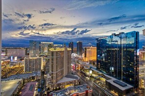 A cityscape with high-rise buildings, including a hotel with a prominent sign. - Vegas Sky Suite | Extended Balcony + Strip Views (Las Vegas)