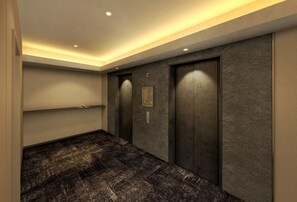 Un ascensor moderno con pantalla digital, piso alfombrado y pared con señal numérica.
