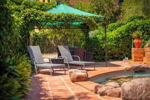 An outdoor patio with a pool, lounge chairs, and a pergola with a green canopy. - Boutique Villa Marcia—Adults Only, 10 minutes from the beach. (Altafulla)