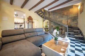 A modern living room with a sectional sofa, a wooden coffee table, and a staircase leading to an upper level. - Boutique Villa Marcia—Adults Only, 10 minutes from the beach. (Altafulla)