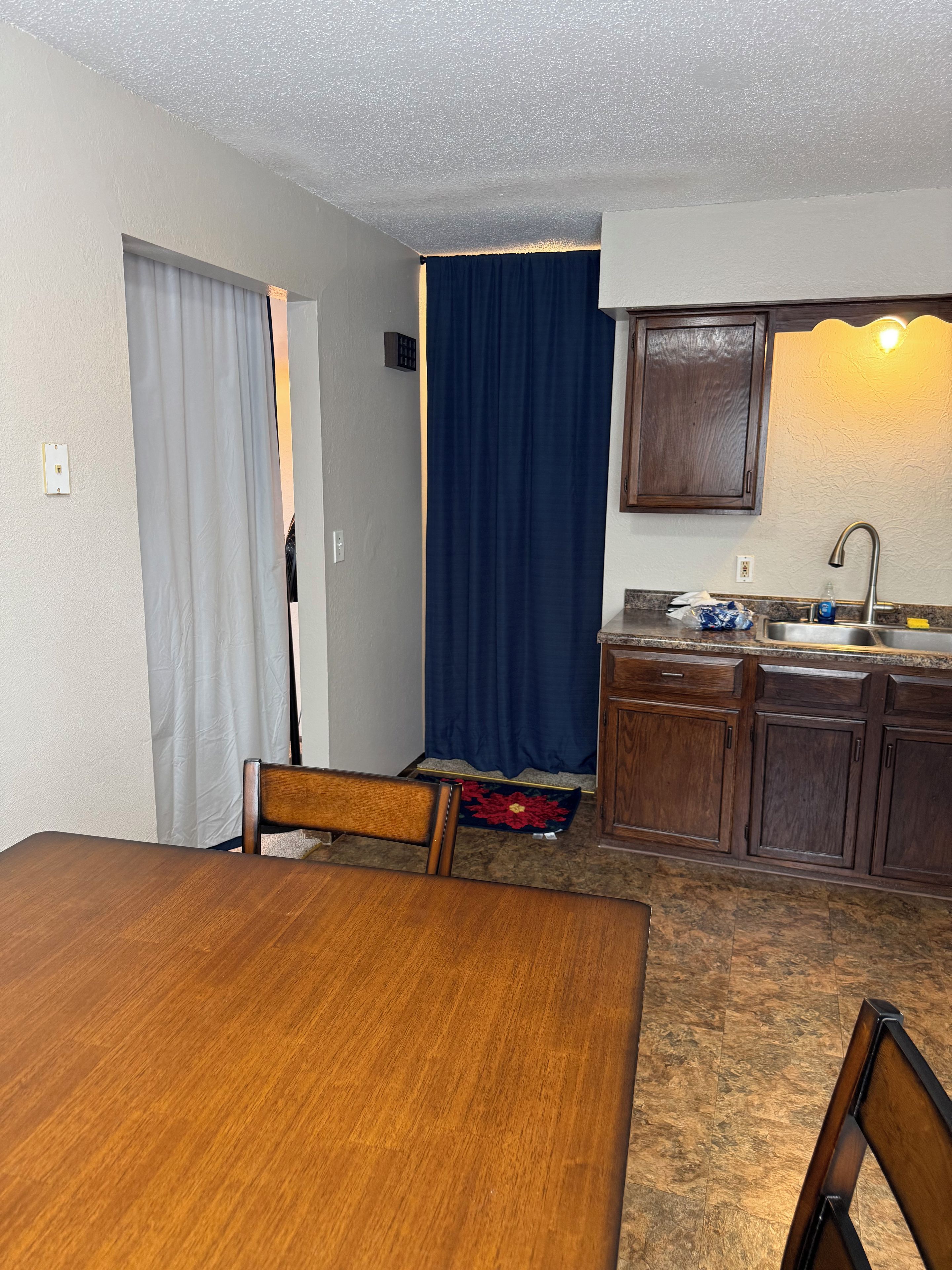 Une cuisine de taille réduite comprenant une table et des chaises, un évier et un meuble de rangement.
