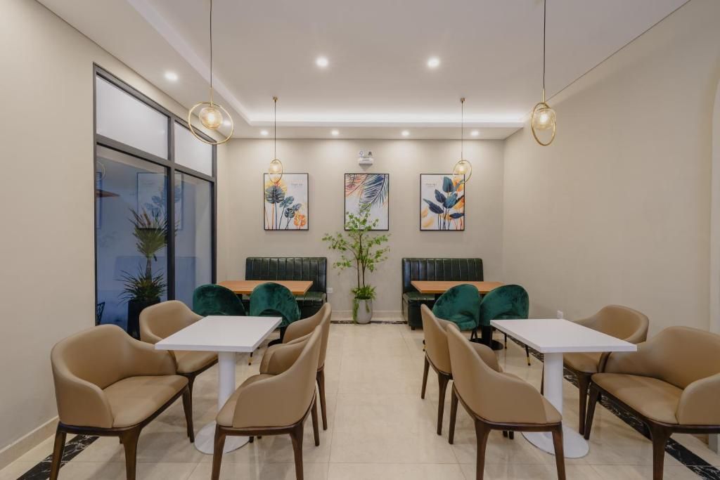 A modern dining area with booths and tables, pendant lighting, and artwork on the walls.