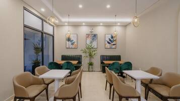 A modern dining area with booths and tables, pendant lighting, and artwork on the walls.