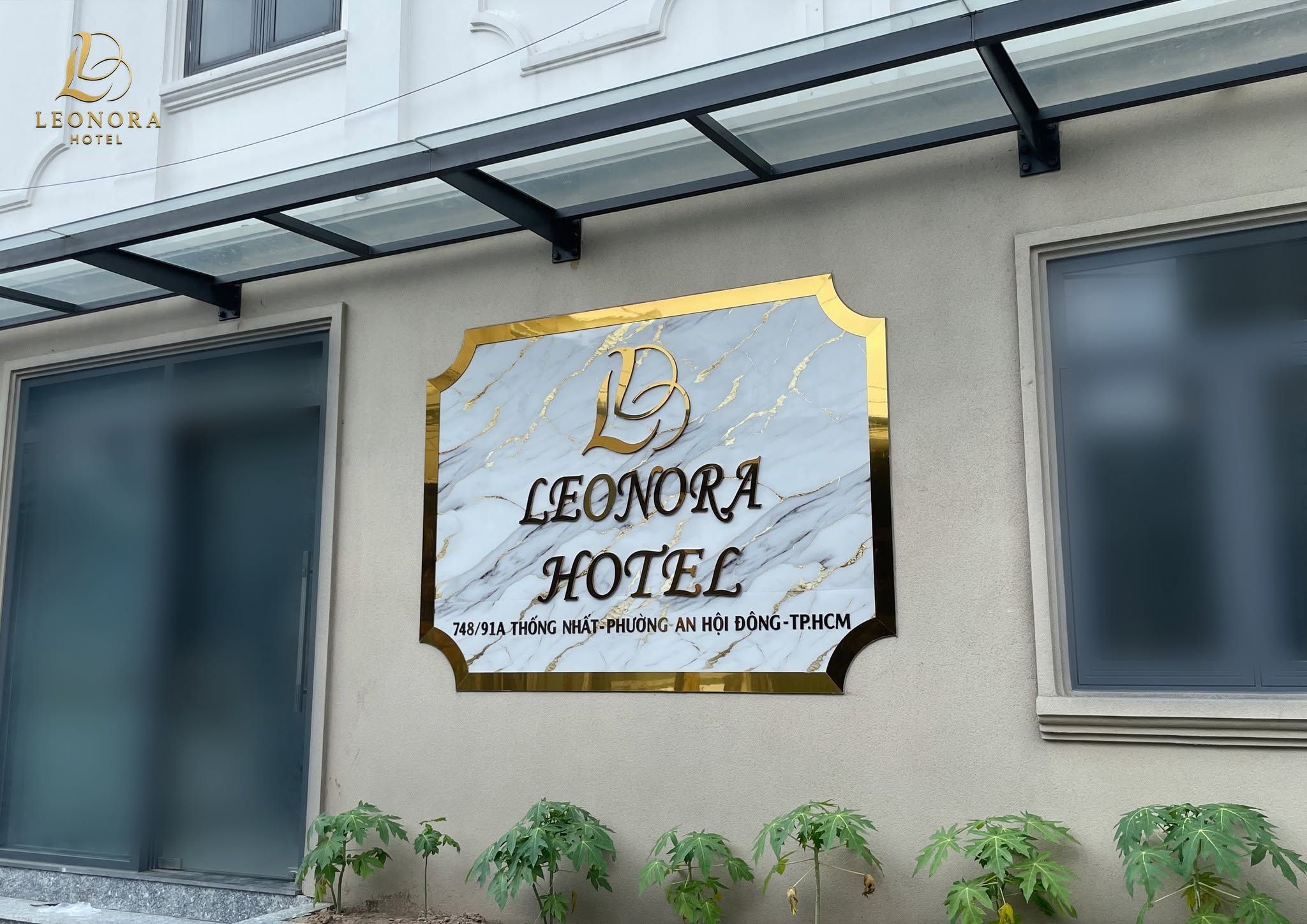 A hotel sign with a marble background and gold lettering.