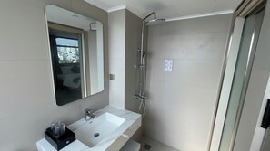 A modern bathroom with a white sink, a mirror, and a shower. - Leonora 3 (Ho Chi Minh Municipality)