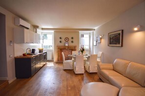 A modern apartment with a kitchen, dining area, and living room. - Luke Loft Lakeside Charm Central Park (Salò)