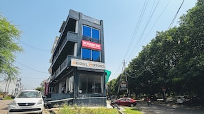 A multi-story building with signage for 'The Elegant Stay' and 'ABDUL MOTORS'. - The Elegent Stay (Greater Noida)