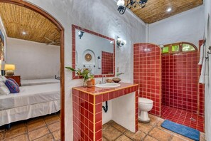 A bathroom with red tiles, a white sink, and a toilet. - Hotel Secret Garden (Granada)