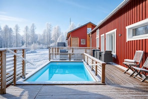 A wooden deck with a pool, a red building, and a snowy landscape. - Arctic Sauna & Aurora Retreat By Lapland Host (Rovaniemi)