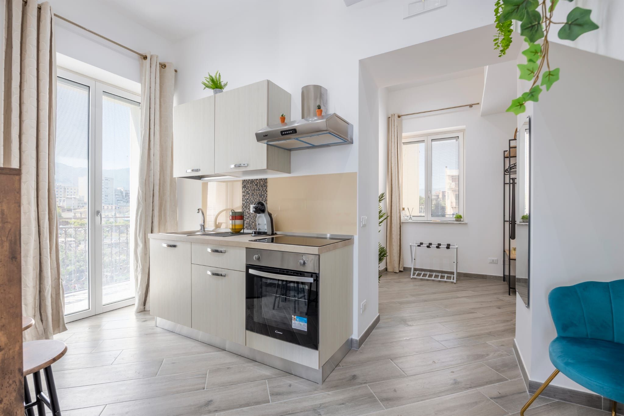 A modern kitchen with a built-in oven, a window, and a view of the city.