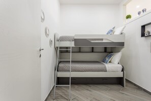 A bunk bed with a ladder, a small shelf with decorative items, and a door. - SANT'ERASMO LUXURY HOME (Palermo)