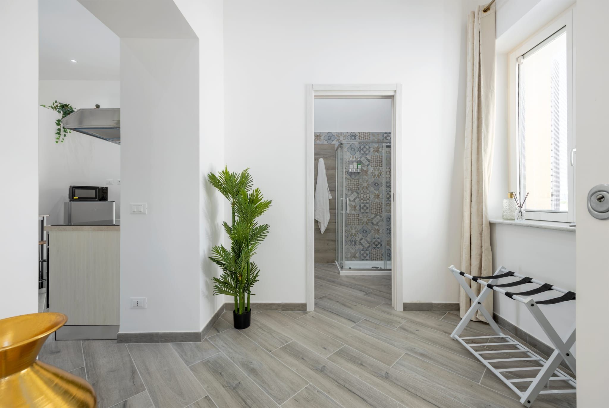 Una cocina moderna con microondas, refrigerador de acero inoxidable y una planta en maceta.
