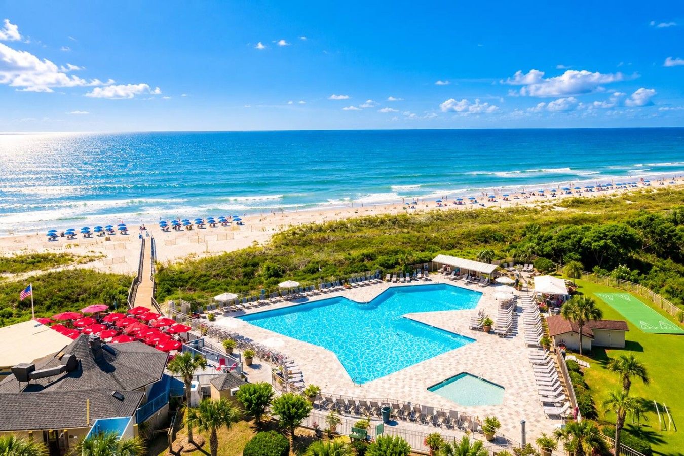 Un complexe hôtelier doté d’une grande piscine, d’un accès à la plage et offrant une vue sur l’océan.