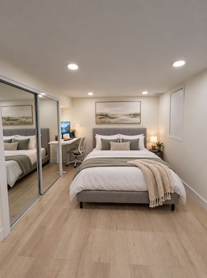 Ein modernes Schlafzimmer mit einem großen Bett, einem Schreibtisch und einem Sessel.