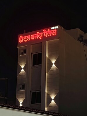 A building with a sign in a foreign language, possibly indicating a hotel or similar establishment. - HOTEL NARMADA PALACE (Ujjain)
