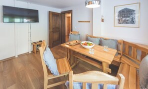 A dining area with a wooden table, benches, and a bowl of fruit. - TRUDI’S TERRACE – 3-BEDROOM ZERMATT HOME WITH MATTERHORN VIEWS (Zermatt)