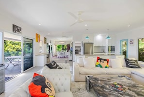 A modern living room with a sofa set, a coffee table, and a dining area with a table and chairs. - Nico’s Butterfly Beach House | Beachfront | 2BR, Sleeps 4 | Spa & Sea Views (Rocky Point)