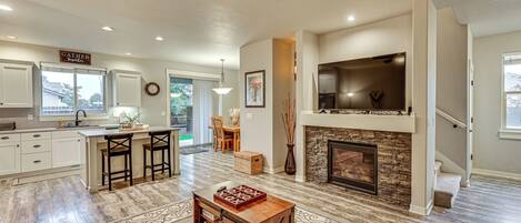 A spacious living area with a fireplace, a television, and a dining area.
