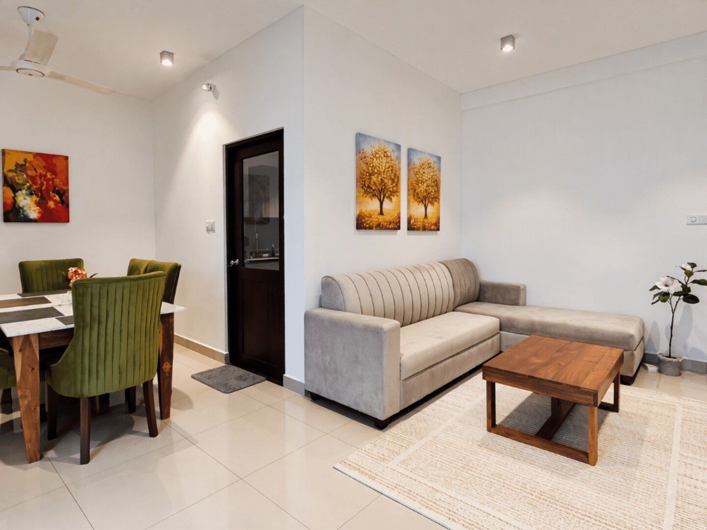 A modern living room with a sofa, coffee table, and dining area with chairs.