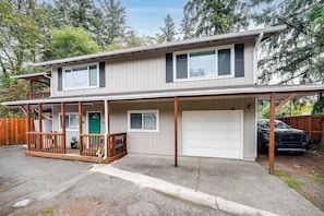 A two-story house with a covered porch, a garage, and a driveway. - Creekside Escape Near Vancouver Medical Center (Vancouver)