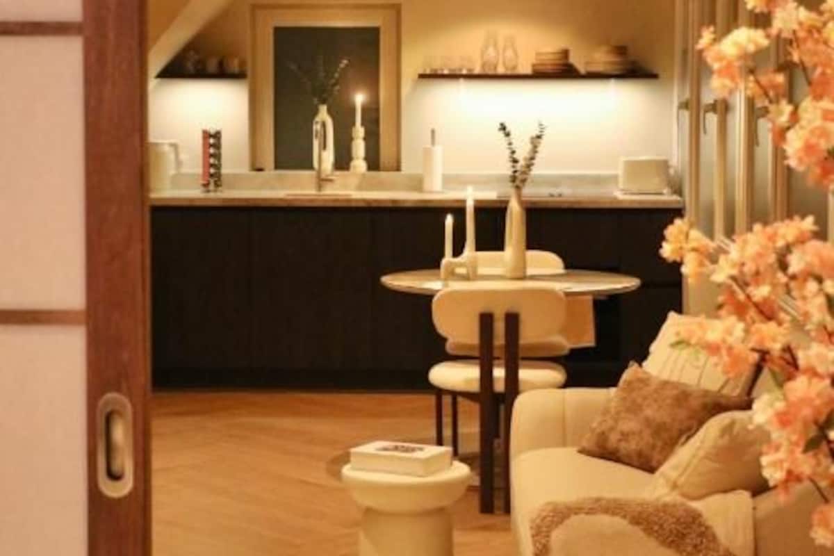 A cozy living room with a sofa, a small round table, and a decorative vase.