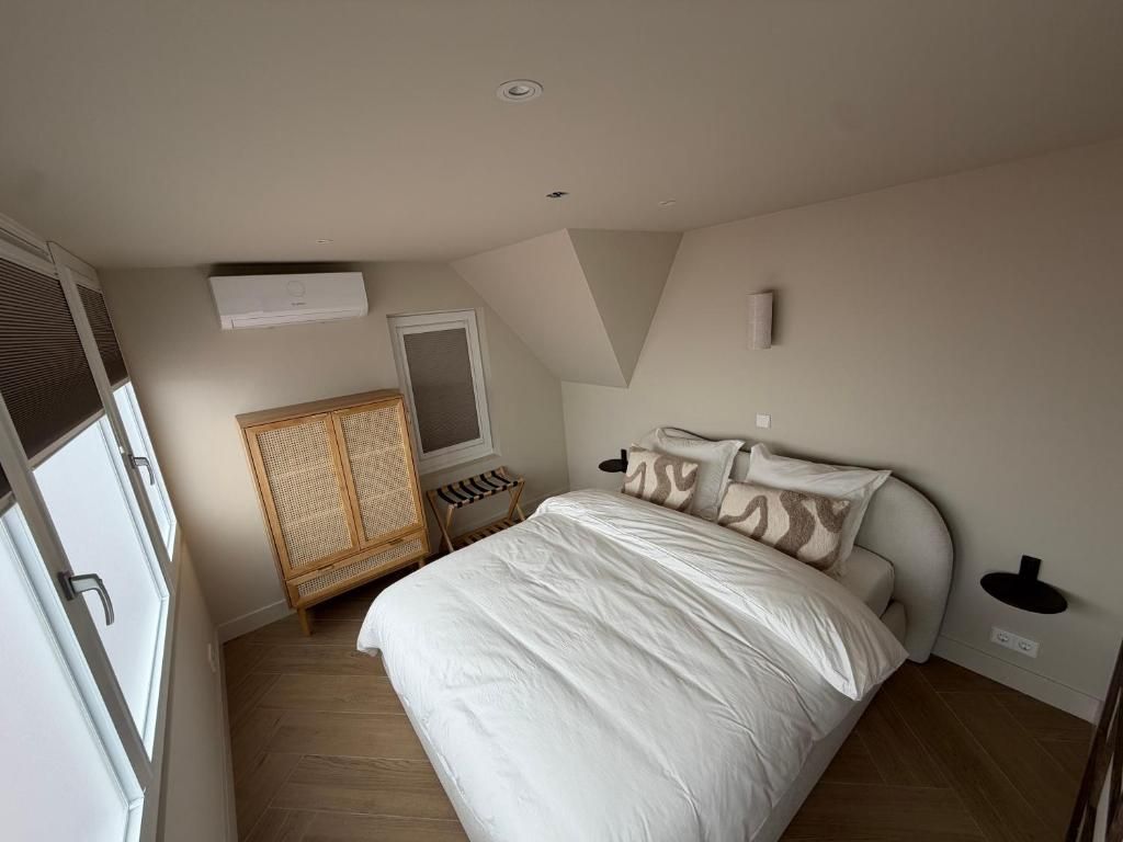 A bedroom with a bed, a wardrobe, a window, and a ceiling light.