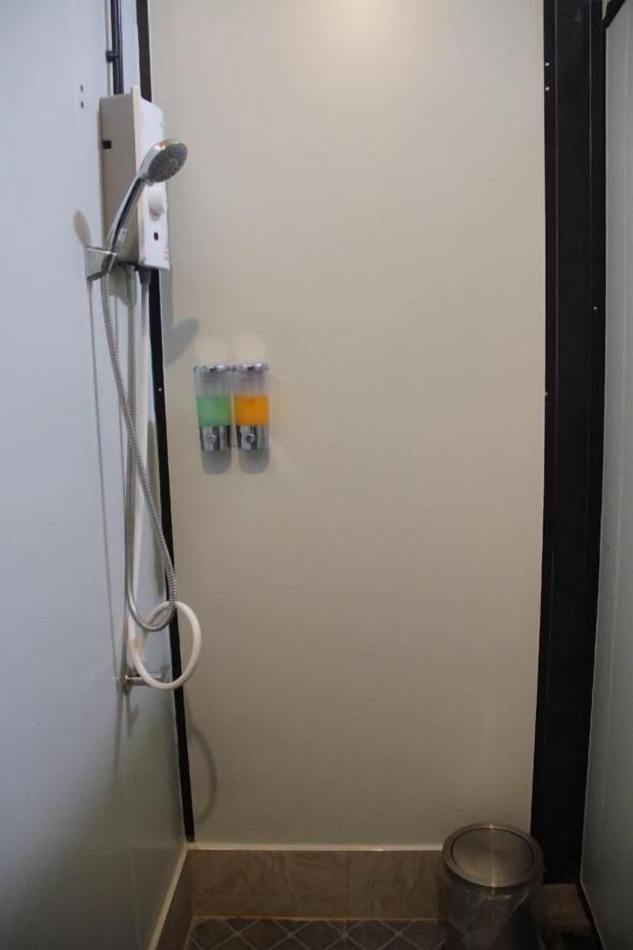 A small bathroom with a shower, a toilet, and a sink.
