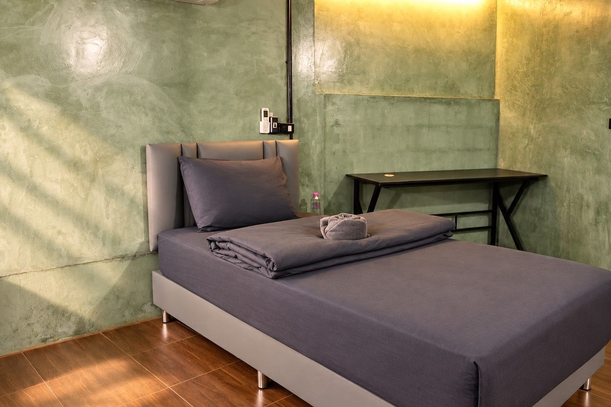 A modern bedroom with a bed, a nightstand, and a table.
