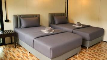 A hotel room with two beds, a small table, and a patterned floor.