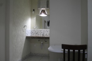A bathroom with a white sink, a mirror, and a ceiling fan. - Brisa da Costa Suites (Macaé)