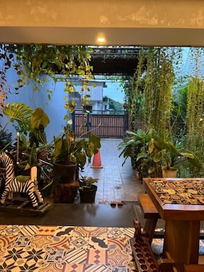 Un jardín interior con plantas en macetas, una escultura de cebra y suelo estampado.