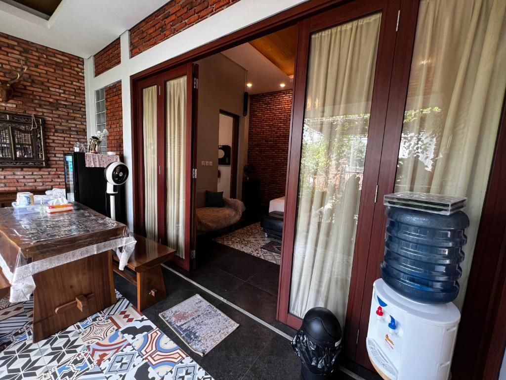 A room with a wooden table, a water dispenser, and a patterned rug.