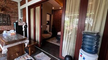 A room with a wooden table, a water dispenser, and a patterned rug.