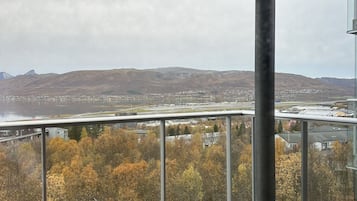 Ein Balkon mit Blick auf eine Stadt und Hügel.