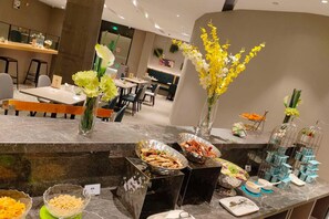 Ein Buffet mit verschiedenen Speisen und floralen Dekorationen.